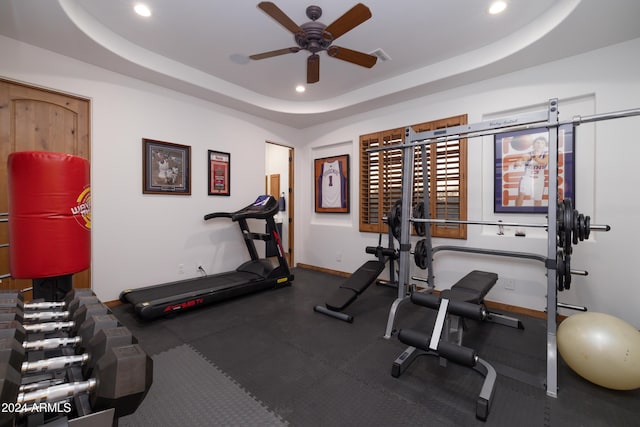 exercise area featuring a tray ceiling and ceiling fan