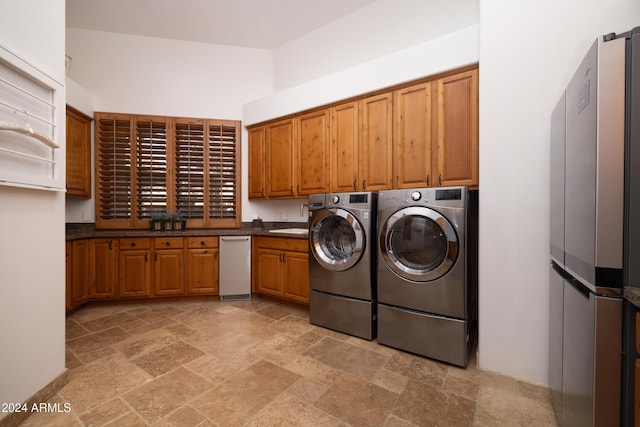 washroom featuring washer and clothes dryer, cabinets, and sink