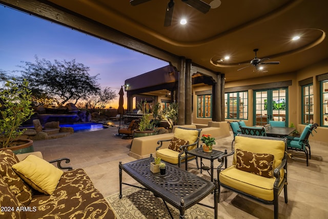 patio terrace at dusk featuring ceiling fan, french doors, and an outdoor hangout area