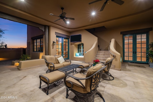 patio terrace at dusk with ceiling fan, french doors, and an outdoor hangout area