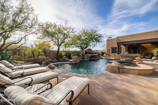 view of pool with an in ground hot tub, pool water feature, an outdoor bar, and a patio