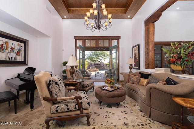 living room featuring a notable chandelier, a high ceiling, and a tray ceiling