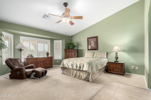 carpeted bedroom featuring a ceiling fan, visible vents, vaulted ceiling, baseboards, and tile patterned floors