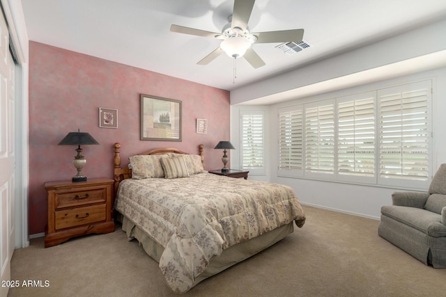 bedroom featuring visible vents, baseboards, a ceiling fan, light colored carpet, and a closet