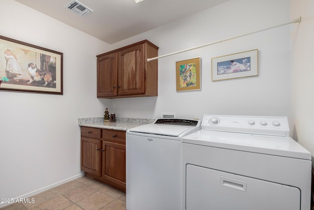 laundry area with cabinet space, light tile patterned floors, baseboards, visible vents, and independent washer and dryer