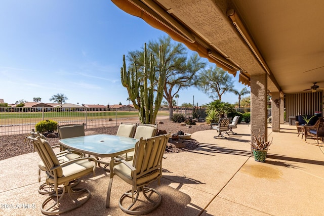 view of patio / terrace with fence, a ceiling fan, and outdoor dining space