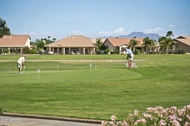 view of property's community with view of golf course and a lawn