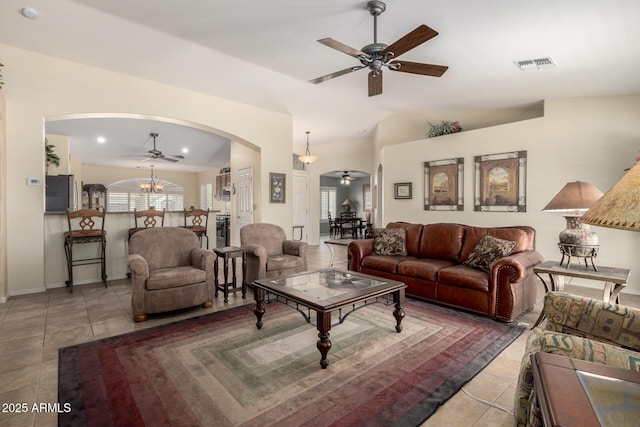 tiled living room featuring arched walkways, recessed lighting, ceiling fan with notable chandelier, visible vents, and vaulted ceiling