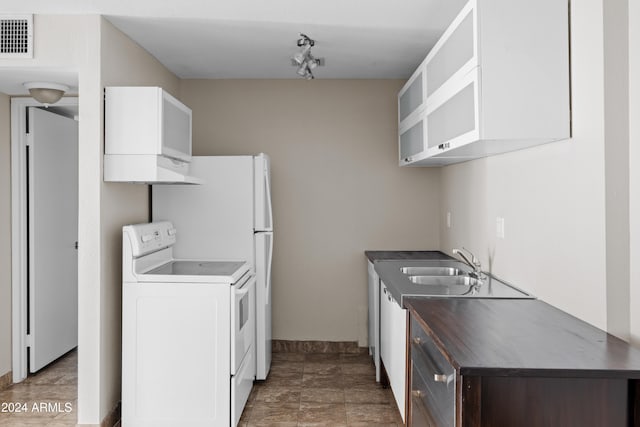 kitchen featuring sink, white cabinets, track lighting, and white range oven