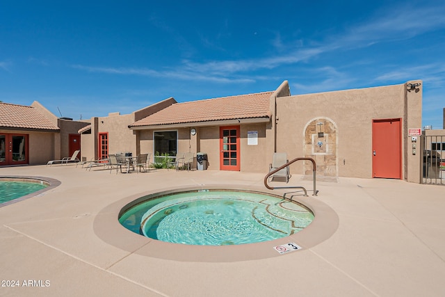 view of swimming pool featuring a community hot tub and a patio