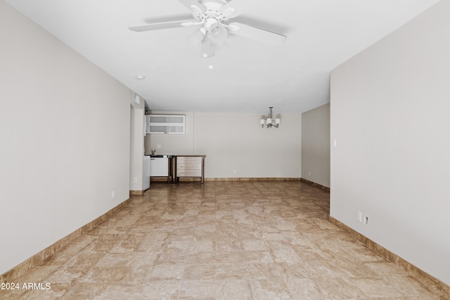 empty room featuring ceiling fan with notable chandelier