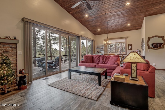 living area with visible vents, ceiling fan with notable chandelier, wooden ceiling, wood finished floors, and high vaulted ceiling