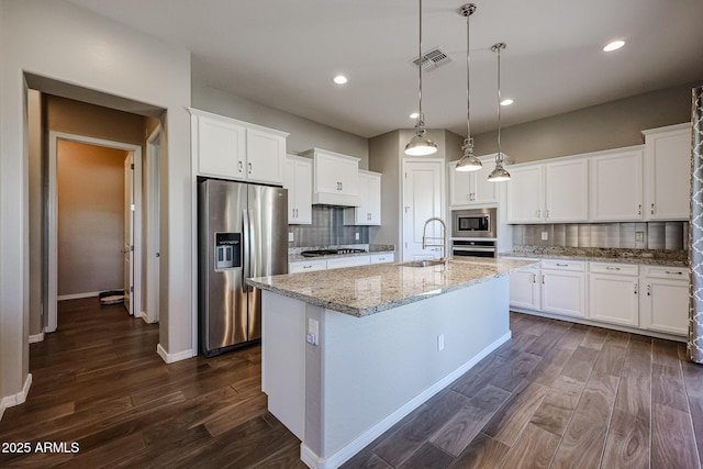 kitchen with a sink, stainless steel appliances, backsplash, visible vents, and dark wood-style floors