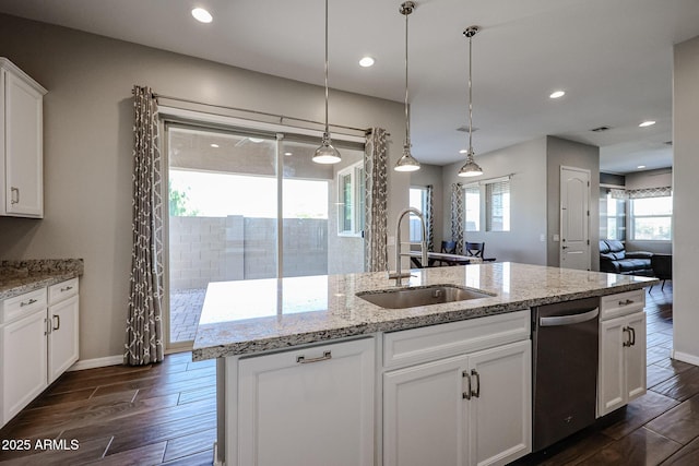 kitchen with a sink, wood tiled floor, white cabinets, and dishwasher