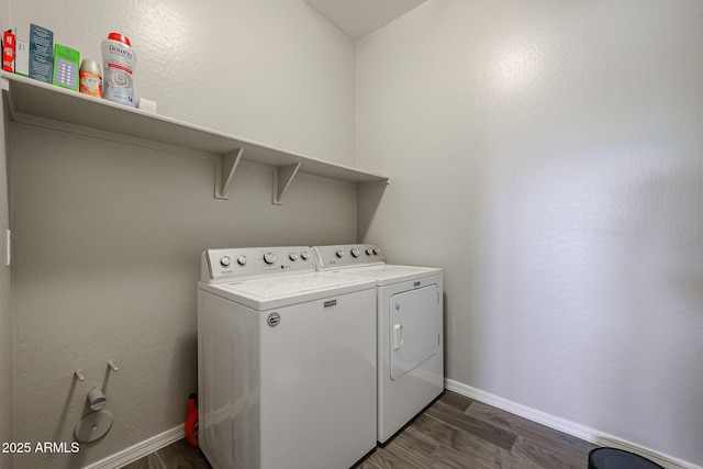 washroom with baseboards, laundry area, washing machine and dryer, and dark wood finished floors