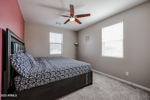 carpeted bedroom featuring baseboards, a ceiling fan, and visible vents