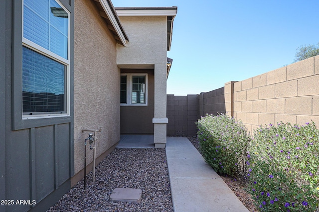 exterior space with stucco siding and fence