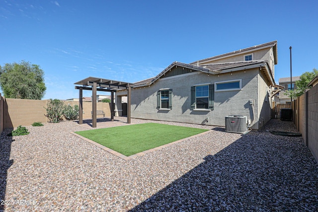 rear view of property featuring central AC, a fenced backyard, a yard, a pergola, and stucco siding