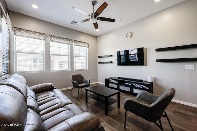 living area with visible vents, a ceiling fan, baseboards, and dark wood finished floors