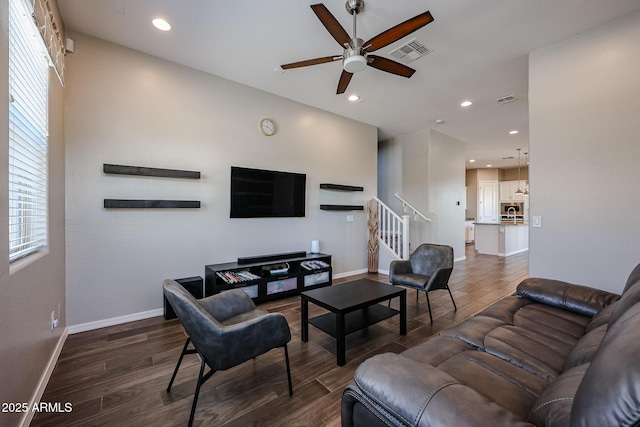 living room featuring stairway, a ceiling fan, dark wood finished floors, and visible vents