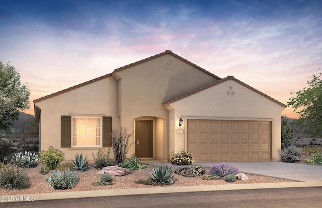 mediterranean / spanish home featuring a garage, concrete driveway, and stucco siding