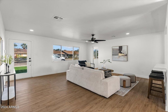 living room featuring ceiling fan and dark hardwood / wood-style floors