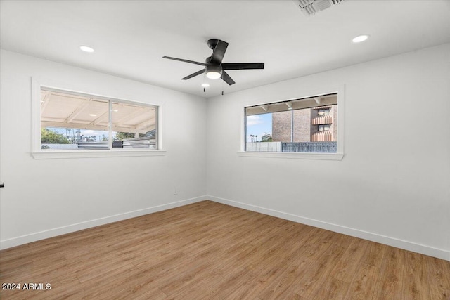 empty room with hardwood / wood-style flooring, ceiling fan, and a wealth of natural light