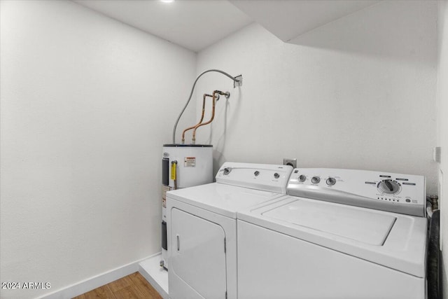 laundry room with washing machine and dryer, electric water heater, and light hardwood / wood-style flooring