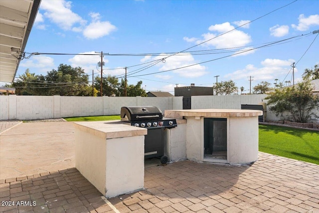 view of patio / terrace with area for grilling, a grill, and an outdoor bar