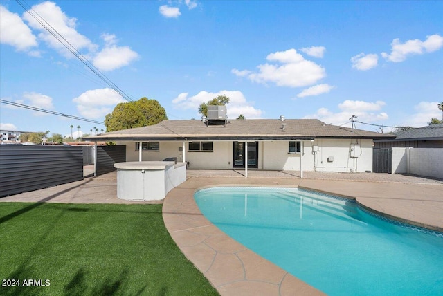 view of swimming pool featuring central air condition unit, a patio area, a lawn, and a hot tub