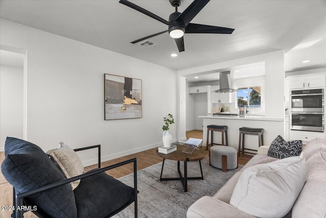 living room with ceiling fan and light hardwood / wood-style floors