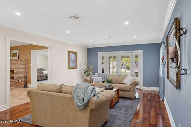 7042 N 13th St, Phoenix, AZ 85020 - living area featuring crown molding, a brick fireplace, baseboards, dark wood-type flooring, and visible vents