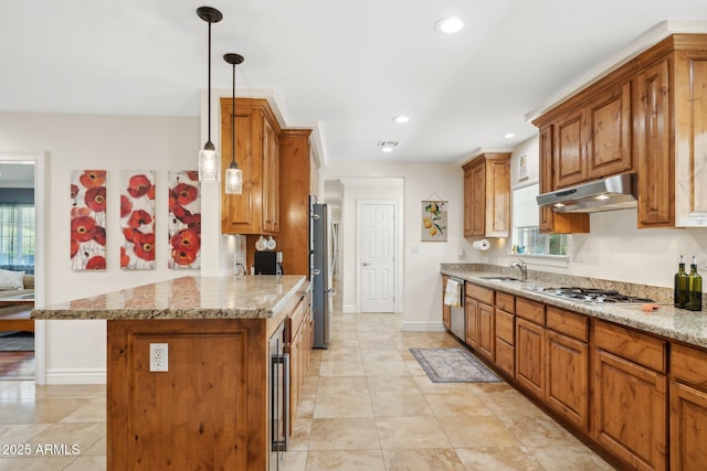 7042 N 13th St, Phoenix, AZ 85020 - kitchen featuring brown cabinetry, under cabinet range hood, light stone counters, a sink, and stainless steel appliances