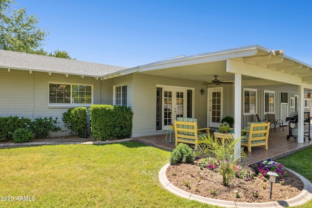 7042 N 13th St, Phoenix, AZ 85020 - rear view of house featuring a lawn, a patio, a ceiling fan, and a shingled roof