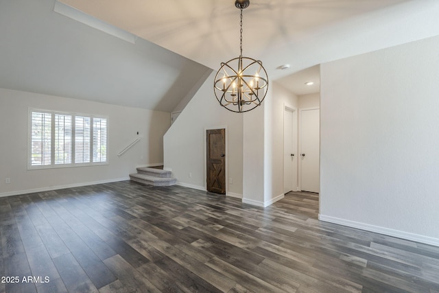 10101 N 91st Ave Unit 111, Peoria, AZ 85345 - unfurnished living room with a chandelier, dark wood-style flooring, baseboards, and vaulted ceiling