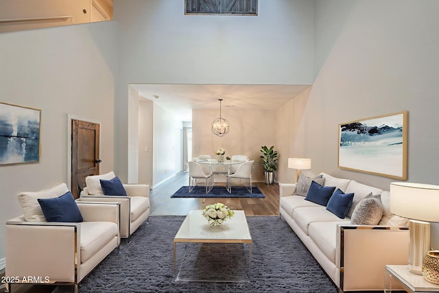 10101 N 91st Ave Unit 111, Peoria, AZ 85345 - living room featuring wood finished floors, a high ceiling, a chandelier, and baseboards