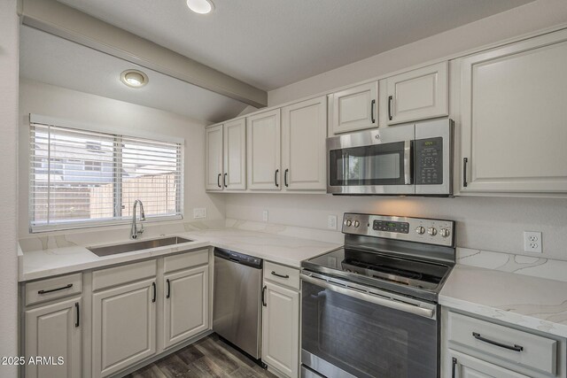 10101 N 91st Ave Unit 111, Peoria, AZ 85345 - kitchen with stainless steel appliances, a sink, white cabinets, dark wood-style floors, and light stone countertops