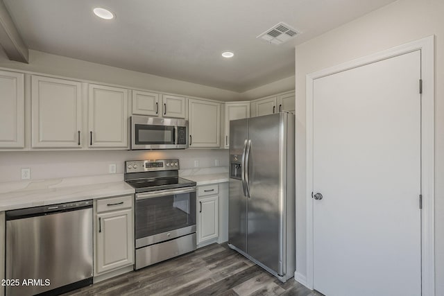 10101 N 91st Ave Unit 111, Peoria, AZ 85345 - kitchen featuring appliances with stainless steel finishes, dark wood-type flooring, recessed lighting, white cabinetry, and light stone counters