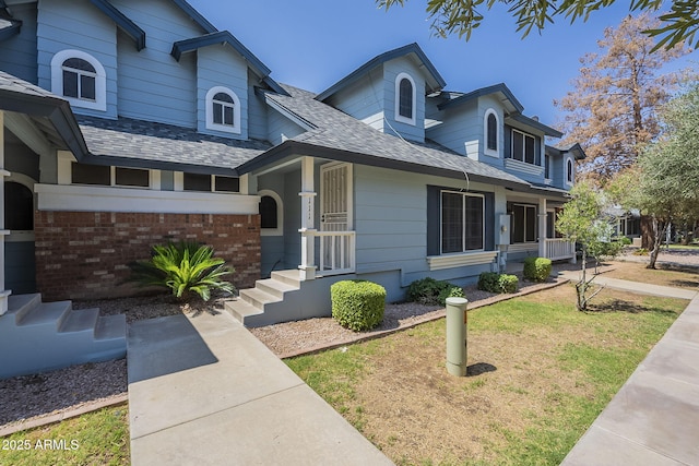 10101 N 91st Ave Unit 111, Peoria, AZ 85345 - traditional-style home with a shingled roof, brick siding, and a front yard