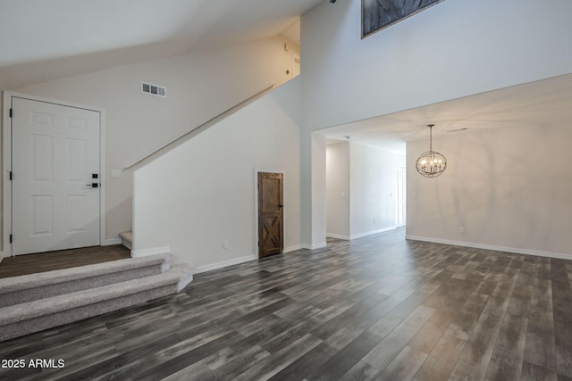 10101 N 91st Ave Unit 111, Peoria, AZ 85345 - unfurnished living room with stairs, a chandelier, dark wood-style floors, high vaulted ceiling, and baseboards