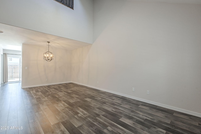 10101 N 91st Ave Unit 111, Peoria, AZ 85345 - spare room featuring dark wood finished floors, a chandelier, and baseboards