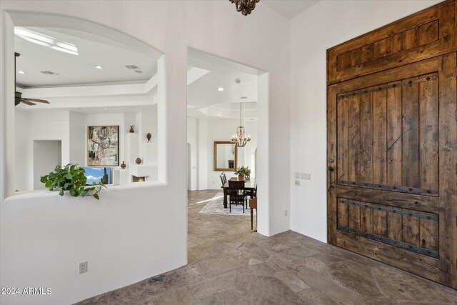 entrance foyer featuring ceiling fan with notable chandelier