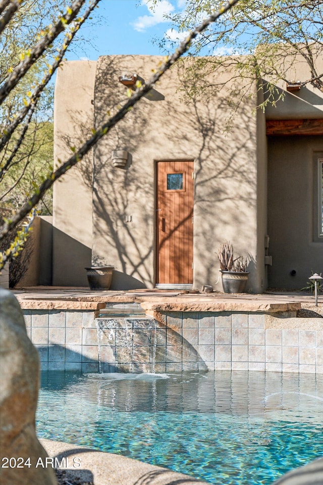 view of swimming pool with pool water feature and sink