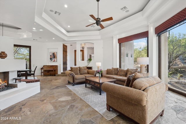 living room featuring a tray ceiling and ceiling fan