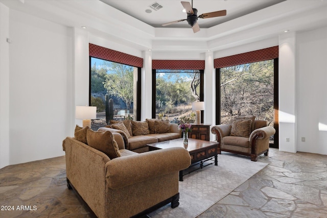 living room featuring a tray ceiling and ceiling fan