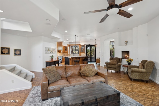 living room with ceiling fan and dark wood-type flooring