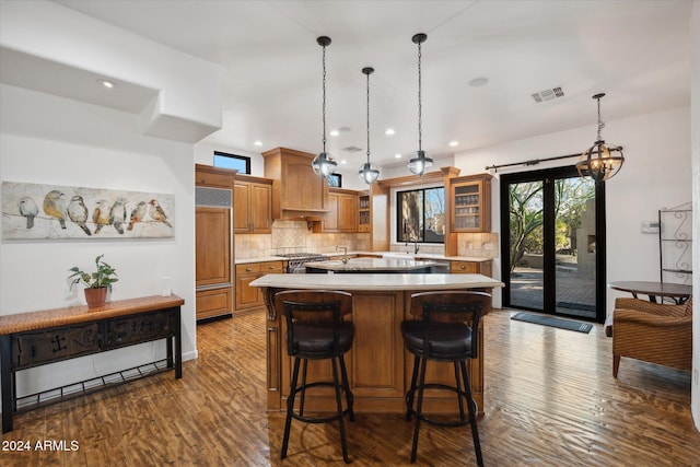 kitchen featuring pendant lighting, a kitchen island, dark hardwood / wood-style flooring, and backsplash