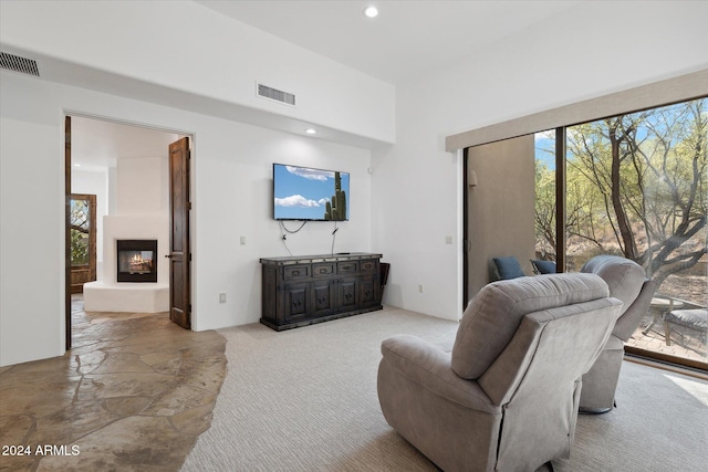 living room featuring a fireplace and light colored carpet