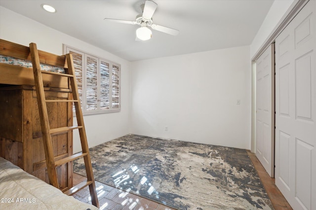 bedroom with hardwood / wood-style floors, ceiling fan, and a closet