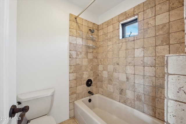 bathroom featuring tiled shower / bath combo and toilet